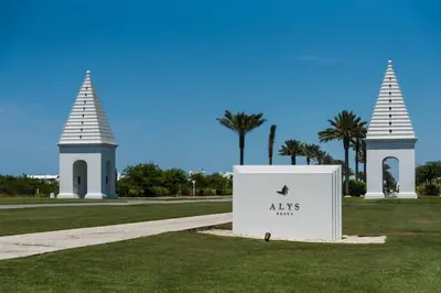 a sign in the grass in front of two towers at Shore Me The Way Close To Beach Bikes in Seacrest