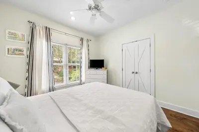 a white bedroom with a bed and a window at The Story House Walk To Beach Pet Friendly in Seacrest