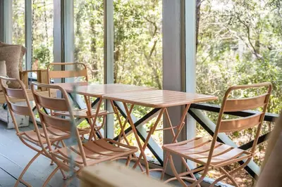 a wooden table and chairs in front of a window at The Story House Walk To Beach Pet Friendly in Seacrest