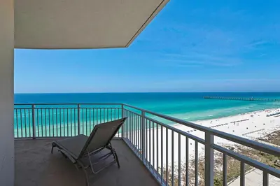 a chair sitting on a balcony overlooking the beach at Aqua Resort 1111 by Emerald Coast Retreats in Panama City Beach