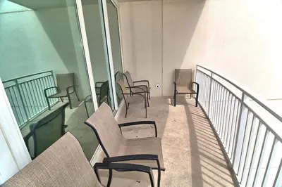 a row of chairs sitting on a balcony at Aqua Resort 1111 by Emerald Coast Retreats in Panama City Beach