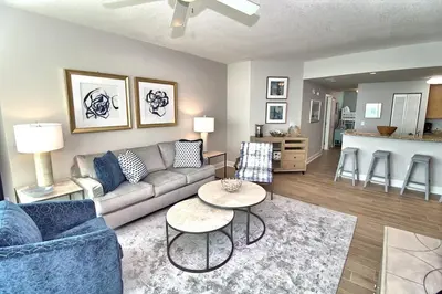 a living room with a couch and a table at Aqua Resort 1111 by Emerald Coast Retreats in Panama City Beach