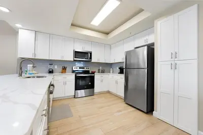 a kitchen with white cabinets and a stainless steel refrigerator at Boardwalk 501 in Panama City Beach
