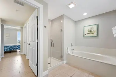 a bathroom with a tub and a shower and a sink at Boardwalk 501 in Panama City Beach