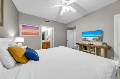 a bedroom with a white bed and a ceiling fan at Twin Palms 603 in Panama City Beach