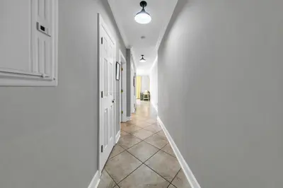 a hallway with white walls and a tile floor at Twin Palms 603 in Panama City Beach