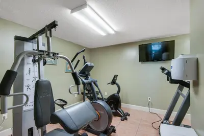 a gym with two exercise bikes and a flat screen tv at Twin Palms 603 in Panama City Beach