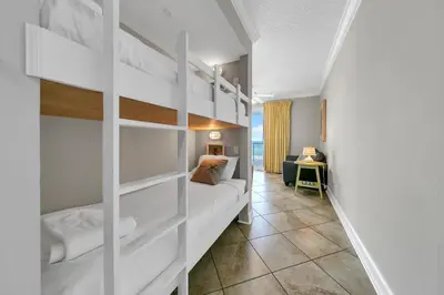 a bedroom with a bunk bed and a desk at Twin Palms 603 in Panama City Beach
