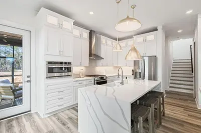 a kitchen with white cabinets and a large island at New Pool 5 Bedroom Screened Porch in Inlet Beach