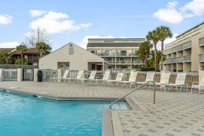 a group of chairs sitting next to a swimming pool at Endless Summer #D1 in Panama City Beach