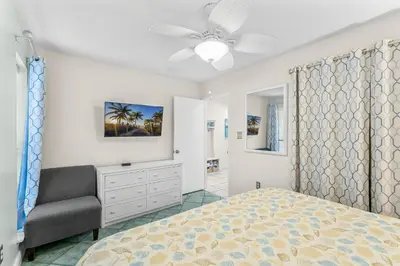 a bedroom with a bed and a chair at Endless Summer #D1 in Panama City Beach