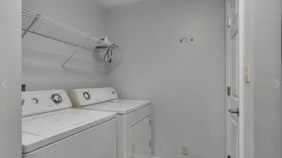 a white laundry room with a washer and dryer at Calypso 402E by Warren Beach Rentals in Panama City Beach