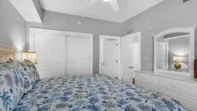 a bedroom with a bed with a blue and white comforter at Calypso 402E by Warren Beach Rentals in Panama City Beach