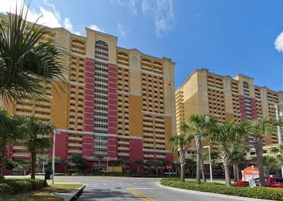 a large building with palm trees in front of a street at Calypso 1204E in Panama City Beach