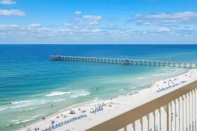 a view of a beach with people and a pier at Calypso 1204E in Panama City Beach