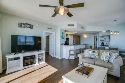 a living room with a couch and a flat screen tv at Calypso 1401E in Panama City Beach