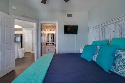 a bedroom with a large blue bed with blue pillows at Calypso 1401E in Panama City Beach