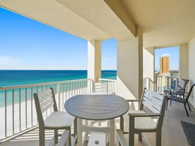 a table and chairs on a balcony with the ocean at Grand Panama 1101 in Panama City Beach