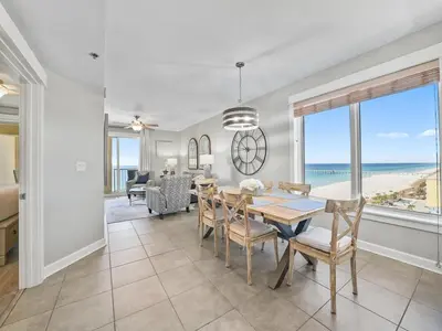 a dining room with a table and a view of the ocean at Grand Panama 1101 in Panama City Beach
