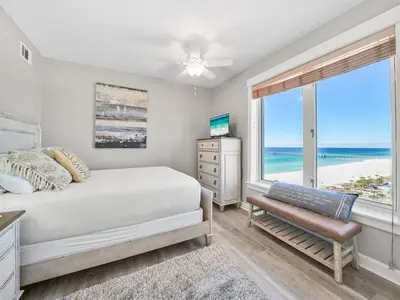 a bedroom with a bed and a window with the ocean at Grand Panama 1101 in Panama City Beach