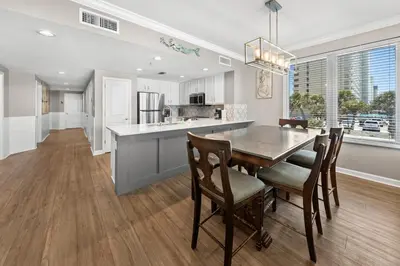 a kitchen and dining room with a table and chairs at Grandview East 101 in Panama City Beach