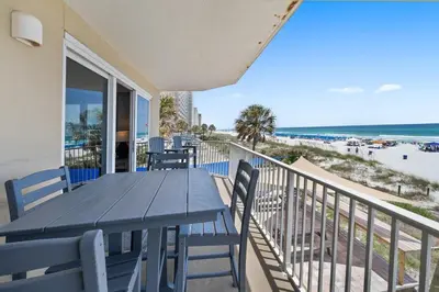 a dining table and chairs on a balcony with the beach at Grandview East 101 in Panama City Beach
