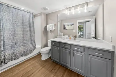 a bathroom with a sink and a toilet and a mirror at Grandview East 101 in Panama City Beach