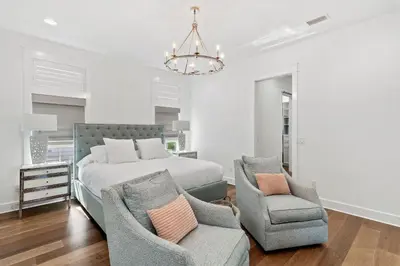 a bedroom with a bed and two chairs and a chandelier at Caspian Blue Paradise 30A Luxe Retreat in Seacrest