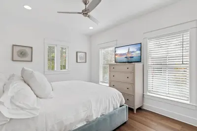 a bedroom with a bed and a dresser with a tv at Caspian Blue Paradise 30A Luxe Retreat in Seacrest