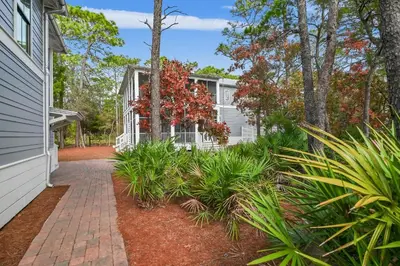 a house with a brick walkway in front of a yard at Caspian Blue Paradise 30A Luxe Retreat in Seacrest