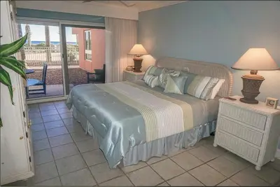 a bedroom with a bed and a balcony at Destin Towers 1E in Panama City