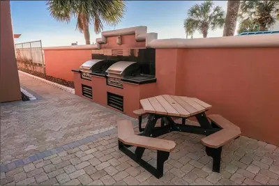 a picnic table and two chairs sitting next to a stove at Destin Towers 1E in Panama City