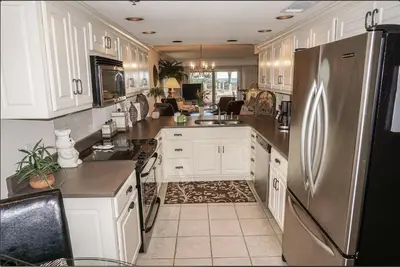 a kitchen with white cabinets and a stainless steel refrigerator at Destin Towers 1E in Panama City