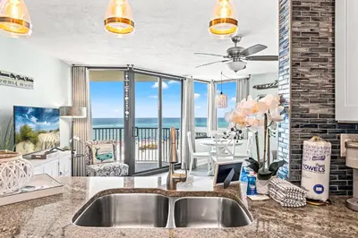 a kitchen with a sink and a view of the ocean at Pelican's Perch at the Sunbird in Panama City Beach