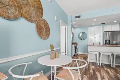 a kitchen and dining room with a table and chairs at Beach front close to attractions condo- Zenwave Retreat in Panama City Beach