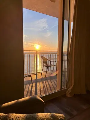 a view of the sunset from a balcony with a chair at Beach front close to attractions condo- Zenwave Retreat in Panama City Beach