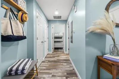 a hallway with blue walls and wooden floors at Beach front close to attractions condo- Zenwave Retreat in Panama City Beach