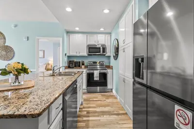 a kitchen with white cabinets and stainless steel appliances at Beach front close to attractions condo- Zenwave Retreat in Panama City Beach