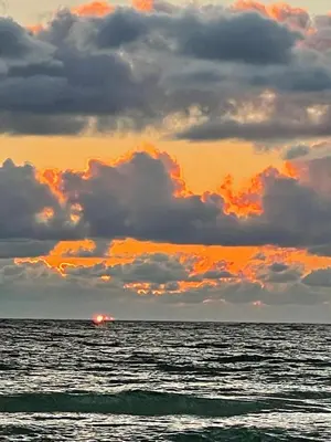 a boat in the ocean under a cloudy sky at Beach front close to attractions condo- Zenwave Retreat in Panama City Beach