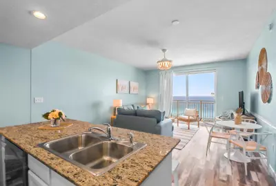 a kitchen with a sink and a living room at Beach front close to attractions condo- Zenwave Retreat in Panama City Beach
