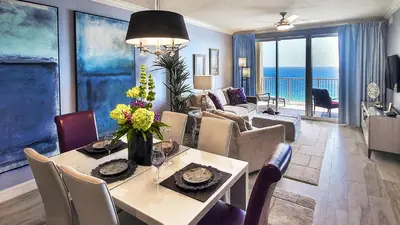 a dining room and living room with a table and chairs at Tropic Winds Luxury Vacation Condo in Panama City Beach