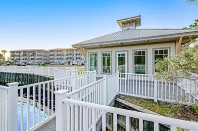 a house with a white fence next to a building at Seagrove Highlands 1304 in Santa Rosa Beach