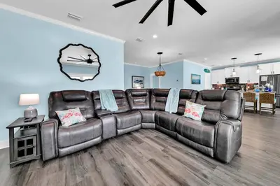 a leather couch in a living room with a table at Lah De Dah by Emerald Coast Retreats in Panama City Beach