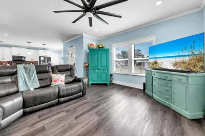 a living room with a couch and a ceiling fan at Lah De Dah by Emerald Coast Retreats in Panama City Beach