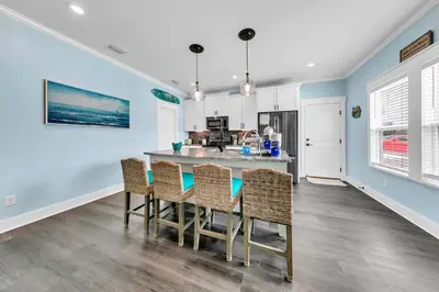 a kitchen and dining room with a table and chairs at Lah De Dah by Emerald Coast Retreats in Panama City Beach
