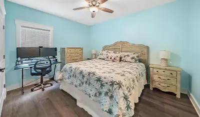 a bedroom with a bed and a desk with a computer at Lah De Dah by Emerald Coast Retreats in Panama City Beach