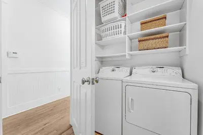a white laundry room with two washer and dryer at Sand On Tap in Inlet Beach