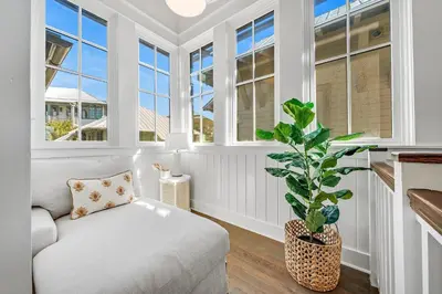 a white room with a couch and a potted plant at Shell Of A View Cottage And Carriage House in Rosemary Beach