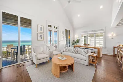 a living room with white furniture and a view of the ocean at Shell Of A View Cottage And Carriage House in Rosemary Beach