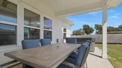 a wooden table on a patio with blue chairs at Pinetree Paradise! in Panama City Beach